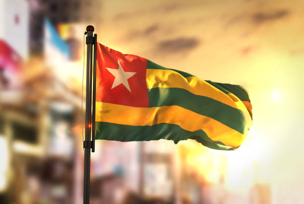 istock Togo Flag Against City Blurred Background At Sunrise Backlight 686184898