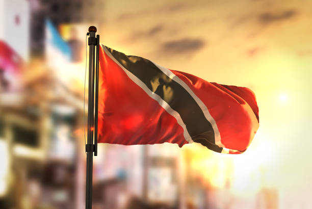 Trinidad and Tobago Flag Against City Blurred Background At Sunrise Backlight Trinidad and Tobago Flag Against City Blurred Background At Sunrise Backlight port of spain stock pictures, royalty-free photos & images