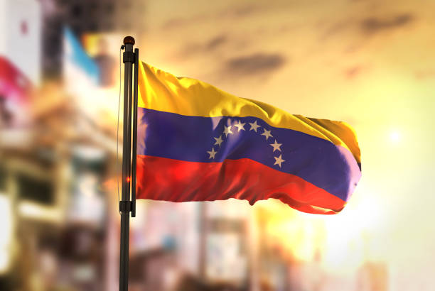venezuela flag against city blurred background at sunrise backlight - venezuelan flag imagens e fotografias de stock
