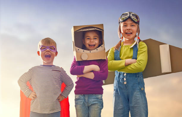 friends games outdoors Children in astronaut, pilot and super hero costumes are laughing, playing and dreaming. Portrait of funny kids on nature. Family friends games outdoors. day stock pictures, royalty-free photos & images