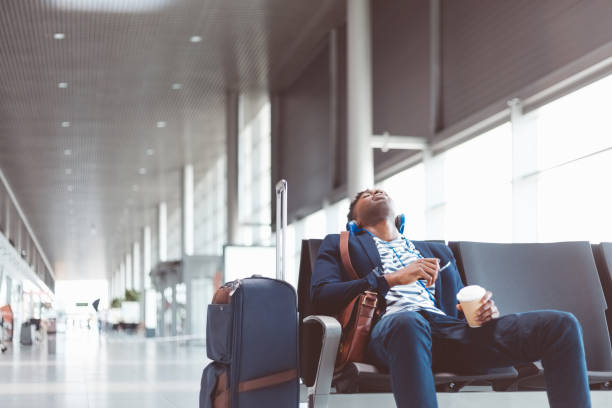 jovem viajante dormindo na sala de espera do aeroporto - bag boredom bored man casual - fotografias e filmes do acervo