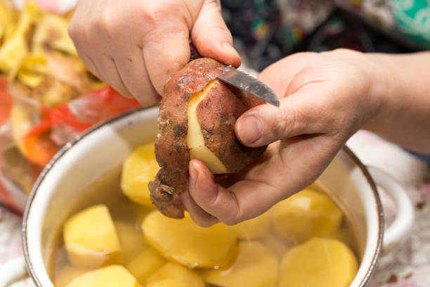 istock The cook cleans the potatoes with a knife 686198012