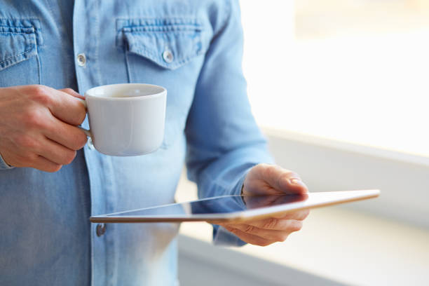istock Man holding tablet and cup of coffee 686199414