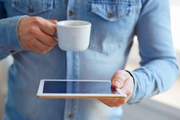 istock Man with white digital tablet and cup of coffee 686199416