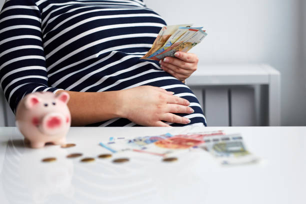 Pregnant woman counting money Close up of pregnant woman counting money maternity money stock pictures, royalty-free photos & images