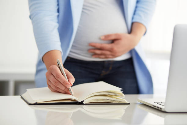istock Young pregnant woman writes to her diary 686205574