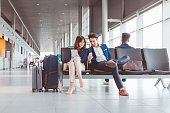 Business couple waiting for flight at airport lounge