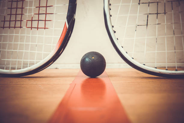 istock squash ball between two squash rackets on the court 686208744