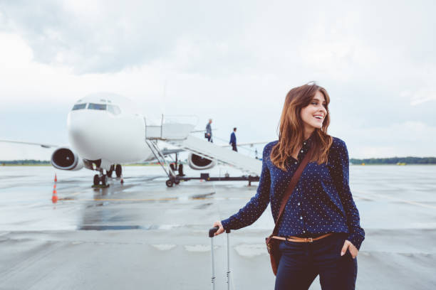mulher de negócios, andar na frente do avião com bagagem - people traveling travel leaving disembarking - fotografias e filmes do acervo