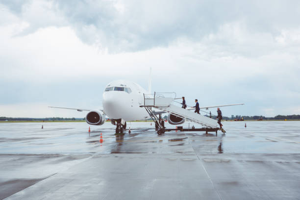 uomini d'affari a bordo di un aereo - runway airport sky wet foto e immagini stock