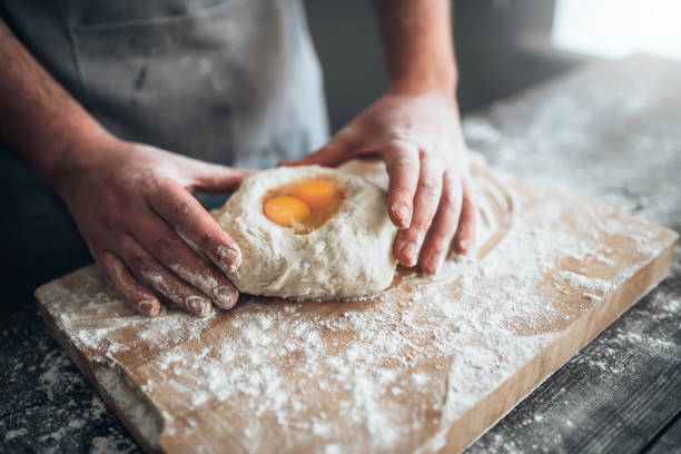 istock Male baker hands mix the dough with egg 686221808