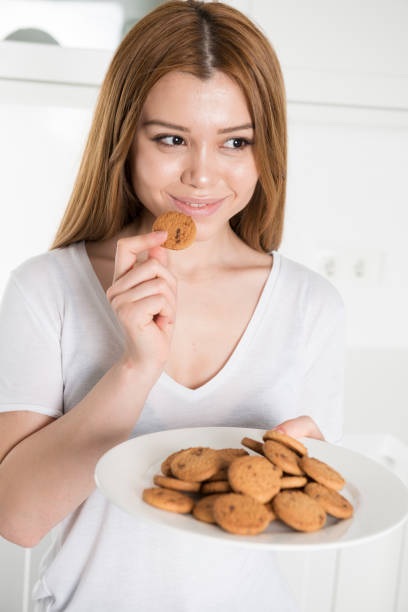 istock Young woman eating biscuit 686222314