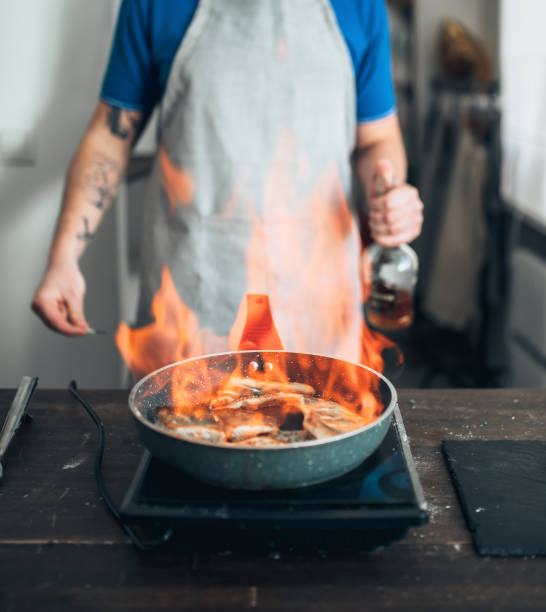 istock Chef against frying pan with fire, fish cooking 686224786