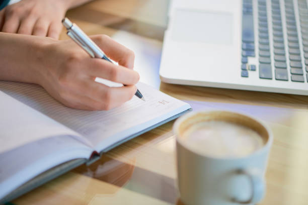 istock Person writing in notebook at the cafe 686235154