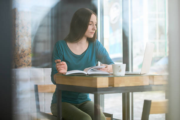 istock Young woman freelance working while being at the cafe 686235208