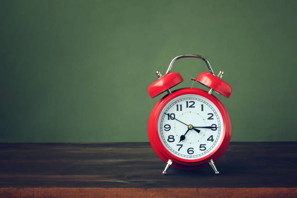 istock Red alarm clock on a wooden table. 686238174