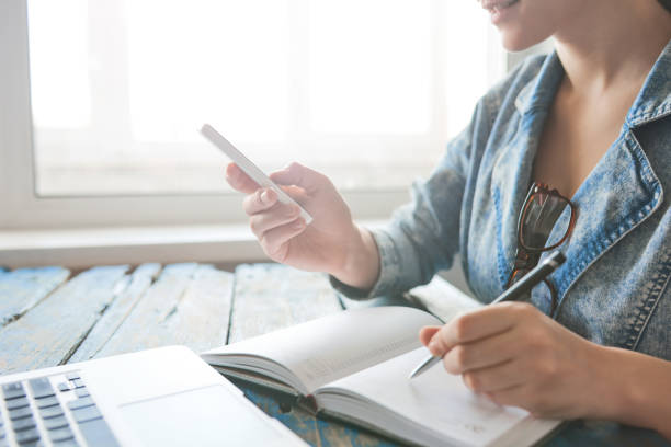 istock Person writing notes and working on the phone 686241438