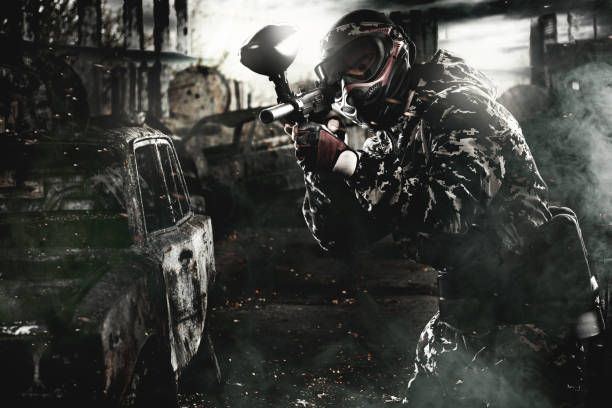 istock Heavily armed masked paintball soldier on post apocalyptic background. Ad concept. 686242370
