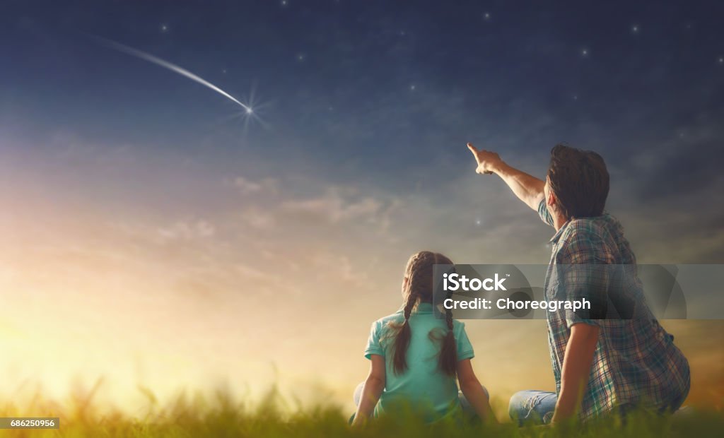 looking at falling star Father and his daughter are looking at falling star. Star Shape Stock Photo