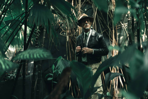 istock Senior explorer standing in dense jungle looking carefully. 686254332
