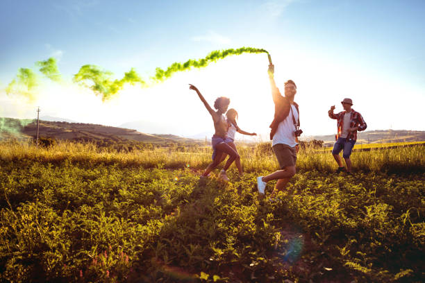 istock Friends holding smoke bombs having fun in a field 686261150