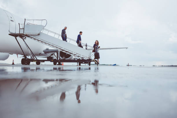 Group of passengers disembarking the airplane Group of passengers disembarking the airplane. Executive business team leaving jet plane. disembarking stock pictures, royalty-free photos & images