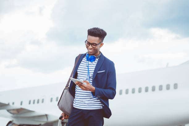 飛行機の前にデジタル タブレットを使用して青年実業家 - digital tablet people business outdoors ストックフォトと画像