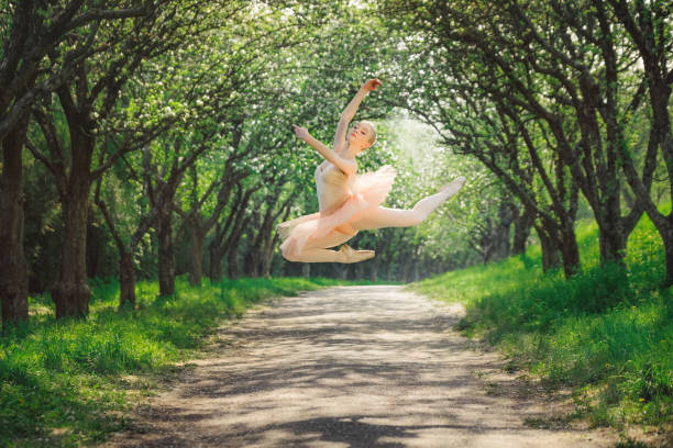 istock Ballerina dancing outdoors and jumping high into the air 686264612
