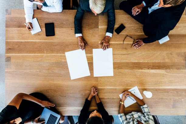 istock Corporate professionals meeting around a table with blank pages 686268164