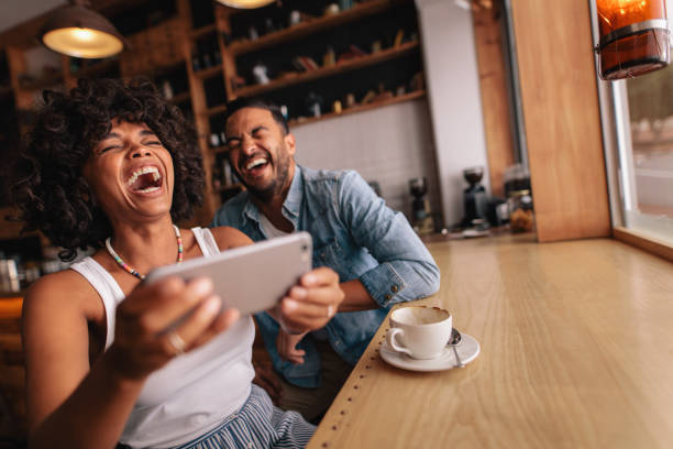 istock Happy young couple having fun with phone at cafe 686270920