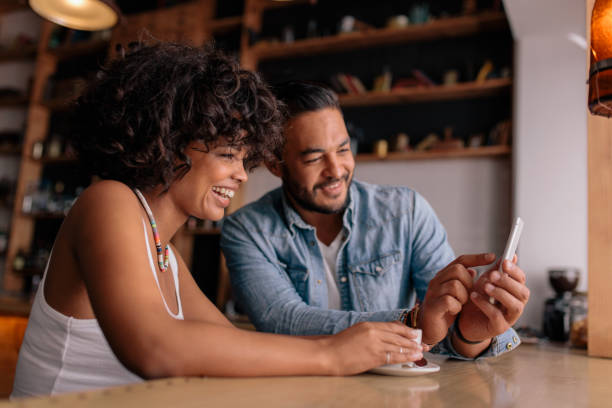 istock Smiling couple at cafe using mobile phone 686271000