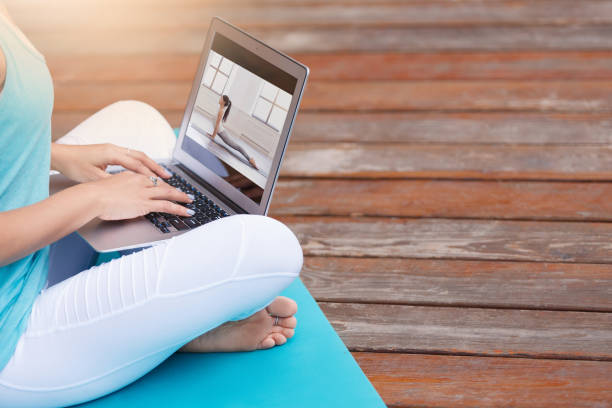 Young happy fitness yoga woman working with her laptop stock photo