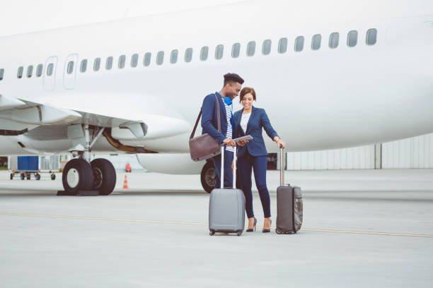 istock Business people using digital tablet in front of airplane 686271174
