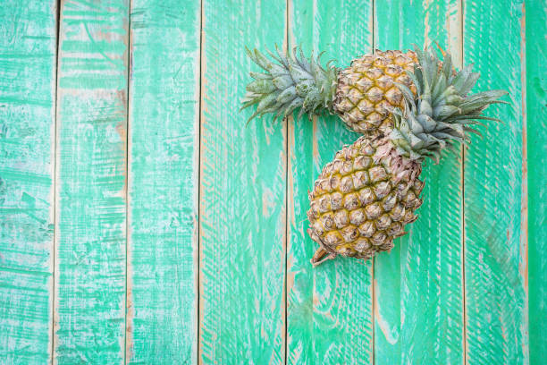 istock Ripe pineapple on a green wooden background 686273900