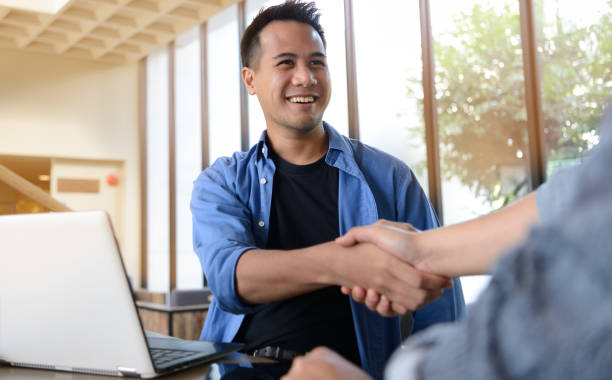 Businessmen shaking hands for business agreement in office Businessmen shaking hands for business agreement in office casual handshake stock pictures, royalty-free photos & images