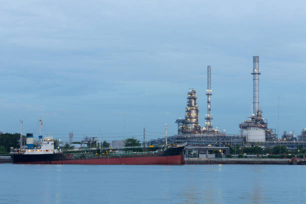 istock Oil tank ship over petrol refinery background river front 686275346