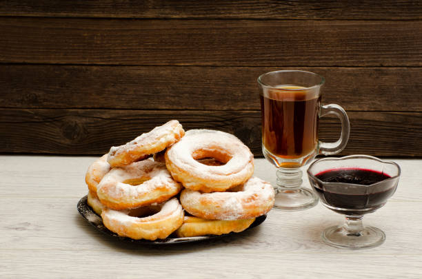 istock Donuts with icing sugar, a mug of tea and currant jam on a wooden background 686275742