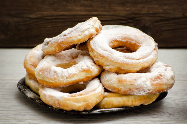 istock Donuts sprinkled with powdered sugar, dark wood background. Close-up, side view 686275808