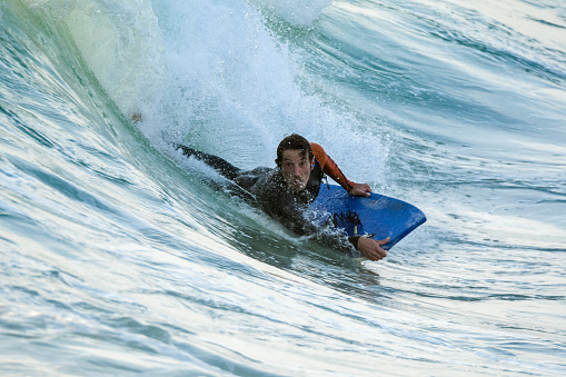 Bodyboarder in action on the ocean waves on a sunny day.