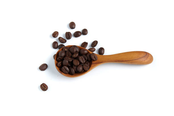 Coffee beans in the wooden spoon on white background.