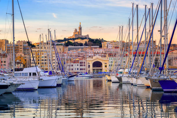 Yachts in the Old Port of Marseilles, France Yachts reflecting in the still water of the old Vieux Port of Marseilles beneath Cathedral of Notre Dame, France, on sunrise marseille stock pictures, royalty-free photos & images