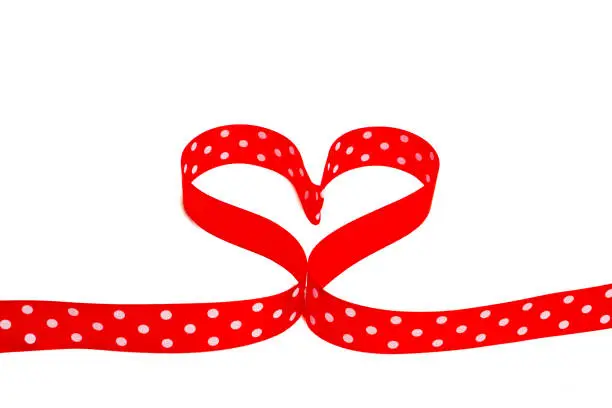 heart shaped polka dot red ribbon on white background
