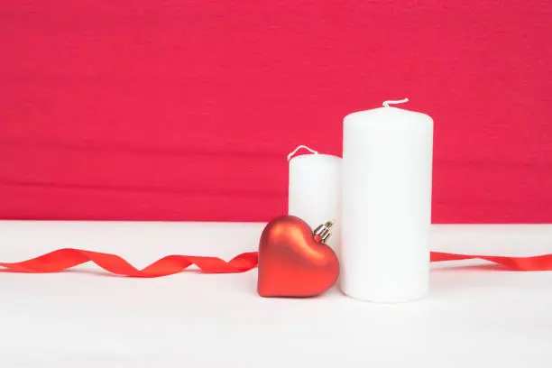 red heart and white candles with red background