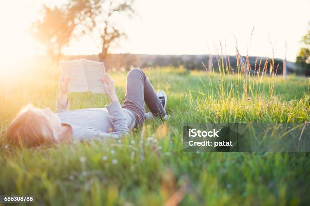 Chica Leyendo Un Libro Fuera Del Encabezado Foto de stock y más banco de imágenes de Leer - Leer, Libro, Aire libre