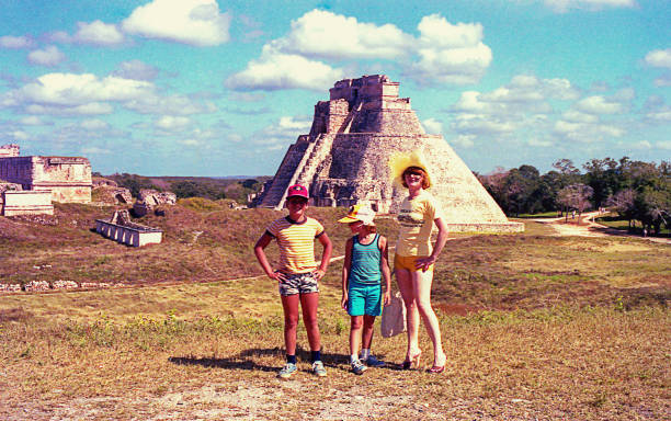 Family visiting the Pyramid of the Magician in Mexico Family visitng the Pyramid of the Magician in Uxmal, in the Yucatan peninsula in Mexico, Mayan Arqueological Site. yucatan photos stock pictures, royalty-free photos & images
