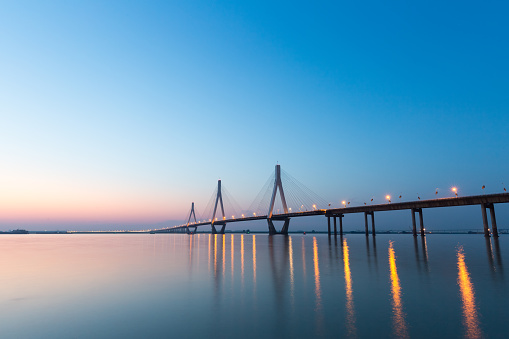 cable stayed bridge on the lake in sunset