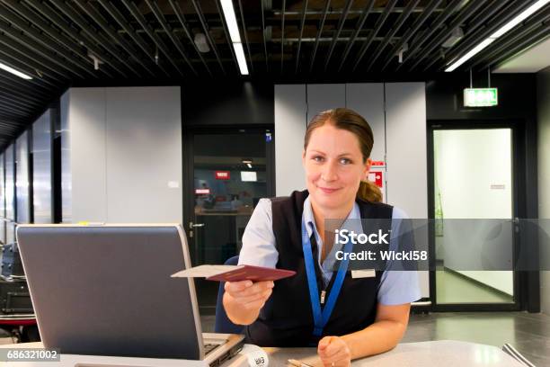 Airline Employee Handing Ticket And Passport To Customer Stock Photo - Download Image Now