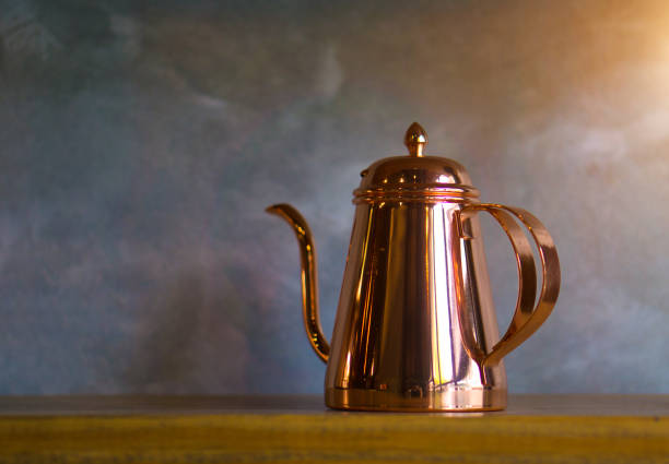 Copper coffee pots on wood shelf for home interior.