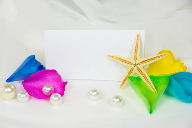 starfish and pearls on white wedding tulle with rainbow rose petals and blank card