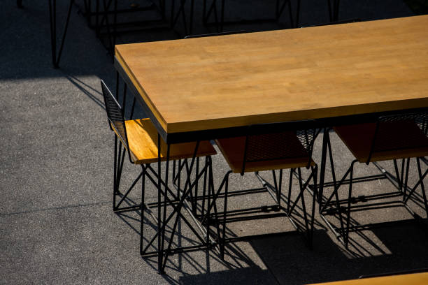 muebles de restaurante y vajilla en una zona al aire libre iluminada - outdoors store beach bench fotografías e imágenes de stock